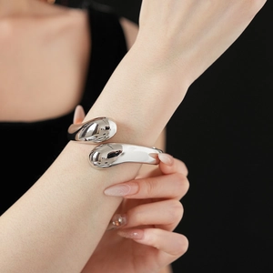 Makroaufnahme des silbernen Tropfenarmbands mit einer polierten Metalloberfläche
