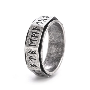 Macro detail of vintage stainless steel rotating ring featuring Nordic Viking runes