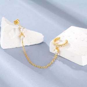 Detailed macro of gold tassel ear cuff with marquise CZ and delicate metal chain