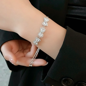 Dettaglio del bracciale regolabile in argento con fiocco in zirconi sul polso