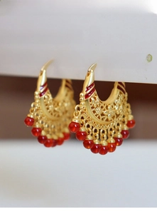 Detailed view of vintage gold hollowed floral earrings with elegant red bead tassels