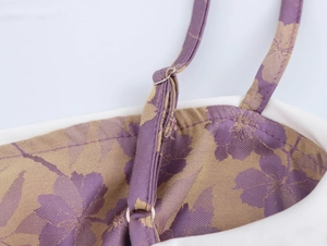 Detail of purple floral jacquard fabric with adjustable shoulder straps and white piping
