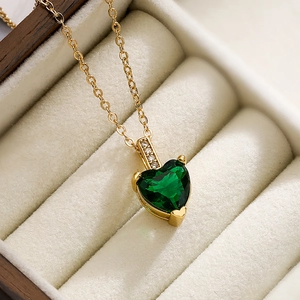 Elegant gold-plated heart necklace with green zircon pendant on a beige velvet jewelry box