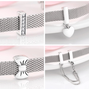 Macro detail of S925 sterling silver mesh bracelet charms with heart and bow accents