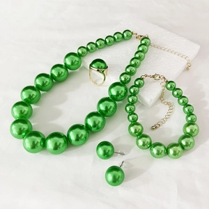 Detailed view of elegant green faux pearl jewelry set with gold finish necklace and earrings