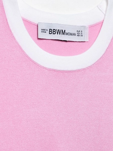 Vue détaillée du haut en tricot rose avec col côtelé blanc contrasté et étiquette