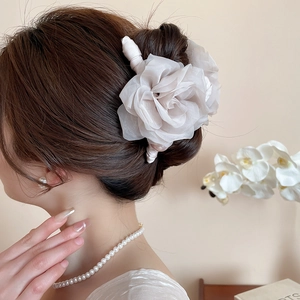 Gros plan d'une pince à cheveux élégante en organza blanc cassé avec perles fines