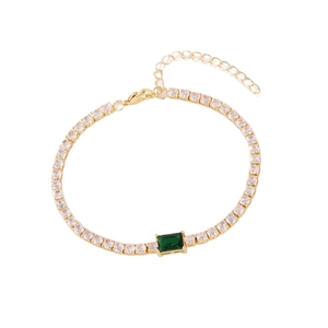 Gold tennis bracelet featuring clear zircons and a central rectangular emerald green stone
