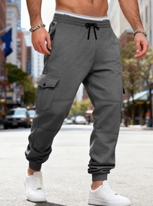 Detail of dark grey cargo sweatpants with drawstring waist and large side flap pocket