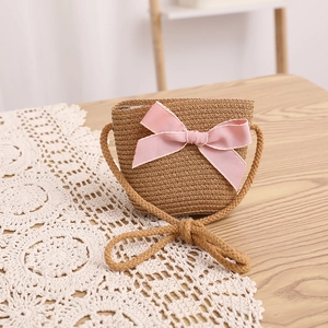 Gros plan détaillé d'un sac à bandoulière en paille pour enfants avec nœud rose