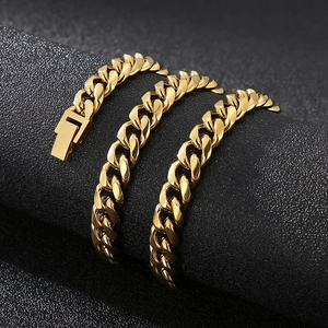 Dettaglio del bracciale a catena cubana dorata con chiusura a scatto su supporto scuro