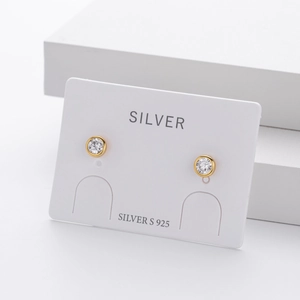 Detailed view of round cubic zirconia stud earrings on white display card
