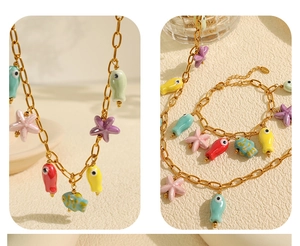 Detailed view of gold chain necklace and bracelet with colorful ceramic sea creature charms