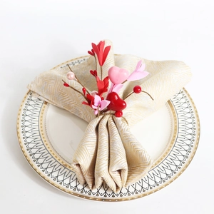 Macro view of a red heart and pink floral napkin ring on a white ceramic plate