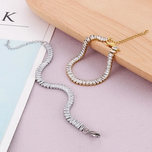 Détails des bracelets en acier argent et or avec zircons carrés et fermoir mousqueton