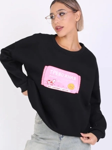 Detail des rosa Grafikdrucks mit russischem Text auf einem schwarzen Sweatshirt