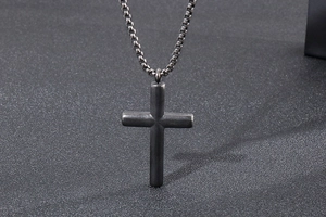 Detailed view of a dark grey stainless steel cross pendant with a classic box chain