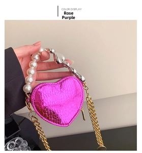 Détail du sac coeur rose pourpre avec poignée en perles et texture serpent