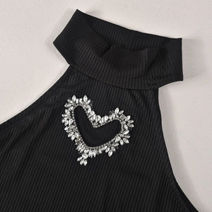 Detailaufnahme von herzförmigen Strasssteinen auf einem schwarzen gerippten Strickoberteil