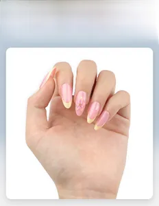 Détail d'ongles roses à coller avec fleurs 3D et pointes françaises jaunes