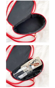 Detail view of red heart crossbody bag interior showing storage capacity for phone and glasses