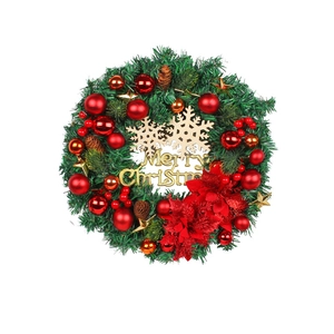 Christmas wreath with green pine needles, red ornaments, and golden Merry Christmas sign