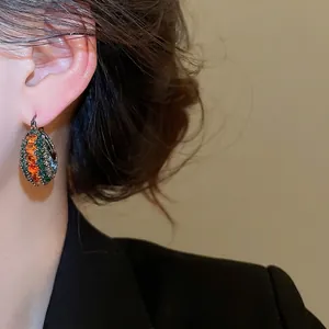 Ethno-Ohrringe im Retro-Stil mit orange-grünen Zirkonia auf Vintage-Metallbasis