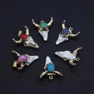 Detailed view of colorful natural stone cow skull pendants with gold plated accents