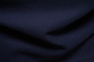 Close-up of navy blue pique polo shirt fabric showing breathable mesh texture and drape
