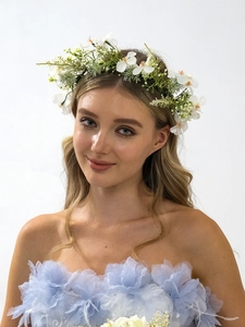 Portrait of a model wearing a white floral wreath headband with a blue petal bridal dress