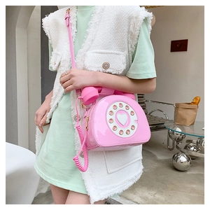 Detailed view of creative pink retro telephone crossbody bag with heart dial detail