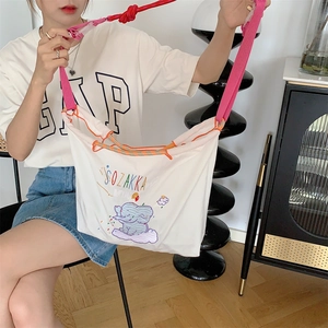 Detail of the elephant embroidery and drawstring closure on this white oxford tote bag