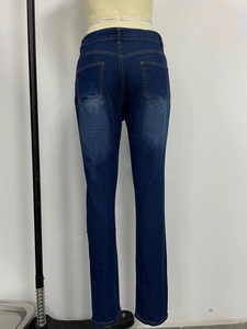 Détail du jean slim à taille haute avec coutures jaunes et poches arrière de femme