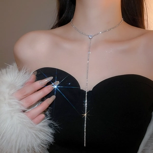 Detail shot of a sparkling silver rhinestone fringe Y-necklace with starburst shine effect
