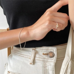 Close-up of S925 sterling silver snake bone bracelet and yellow gemstone ring on a hand