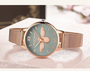 Détail de la montre femme en or rose avec relief d'abeille 3D sur cadran gris-vert