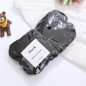 Detail of high-elastic black seamless hair ties on white fabric with a small bear decoration