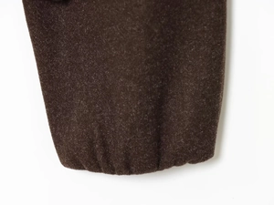Detail of warm brown fleece fabric texture and elastic ribbed cuffs on a hooded jacket