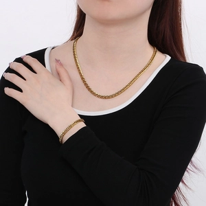 Poliertes goldenes Panzerketten-Set aus Halskette und Armband am weiblichen Modell