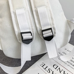 White canvas backpack with adjustable black strap buckles shown on a minimalist background