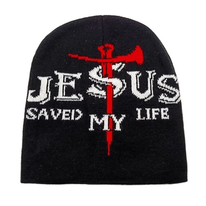 Dettaglio del testo Jesus Saved My Life e croce rossa ricamata su berretto nero a maglia