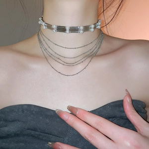 Détail d'un collier multi-rangs argenté avec perles sur le cou d'un modèle