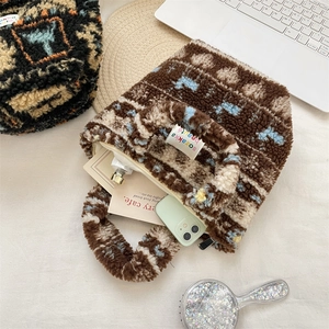 Top view of plush faux shearling handbag with abstract floral patterns and zipper detail
