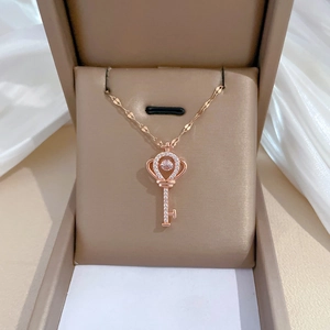 Macro shot of rose gold crown key pendant with diamonds in a luxury jewelry gift box