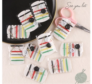 Macro shot of portable sewing kit with six color threads, needles, and buttons set