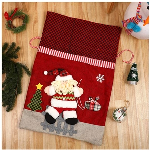Detail of Christmas Santa Claus drawstring gift bag on wooden floor with festive decorations