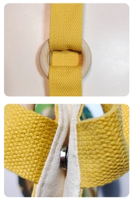Detail of yellow canvas bucket bag with natural wooden ring and silver magnetic buckle