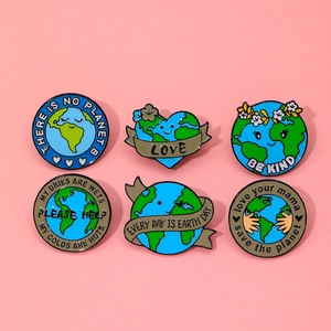 Detailed close-up of six enamel Earth Day badges with eco-friendly slogans on pink background