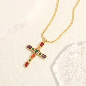 Dettaglio della collana con croce dorata e pietre preziose colorate su catena a corda