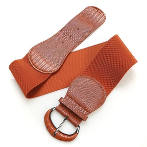 Detail of a wide elastic waist belt featuring orange-brown crocodile pattern and D-ring buckle